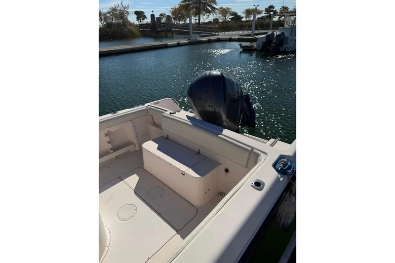 Slide: The Image of 1998 Grady-White Advance 247 boat docked, featuring spacious seating and outboard motor. - 4