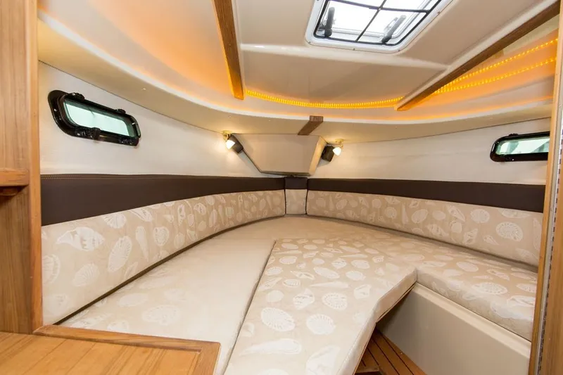 Slide: The Image of Manufacturer Provided Image: 2022 Ranger Tugs R-27 cabin interior with cozy seating and ambient lighting. - 16