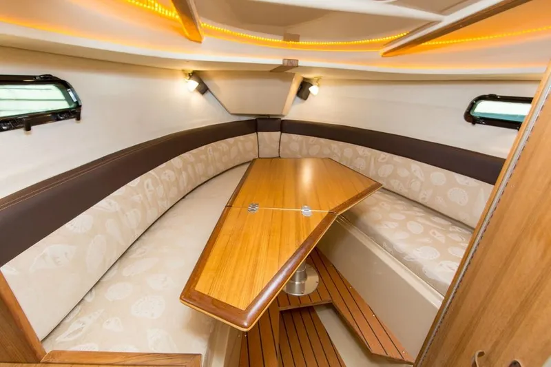 Slide: The Image of Manufacturer Provided Image: 2022 Ranger Tugs R-27 cabin interior with wooden table and cushioned seating. - 17