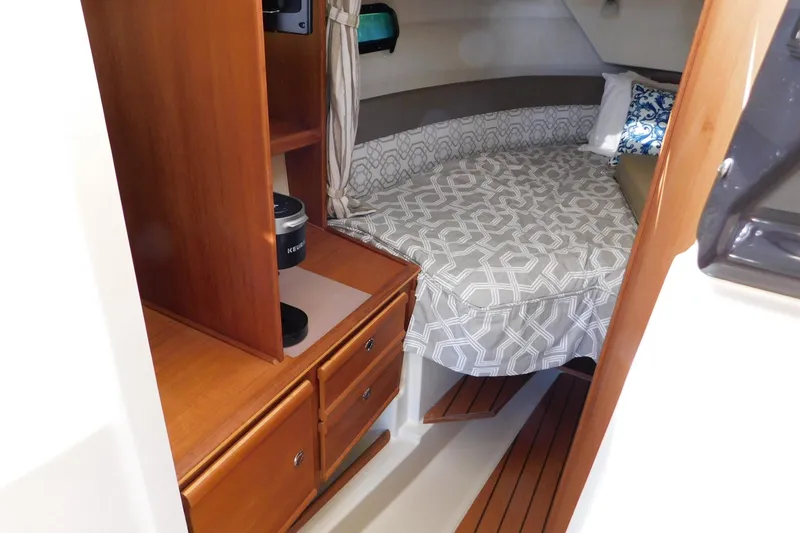 Slide: The Image of 2022 Ranger Tugs R-27 cabin interior with cozy bed and wooden cabinetry. - 22