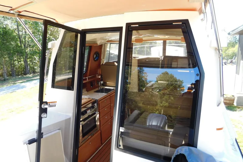 Slide: The Image of 2022 Ranger Tugs R-27 interior view with kitchen and seating area. - 30