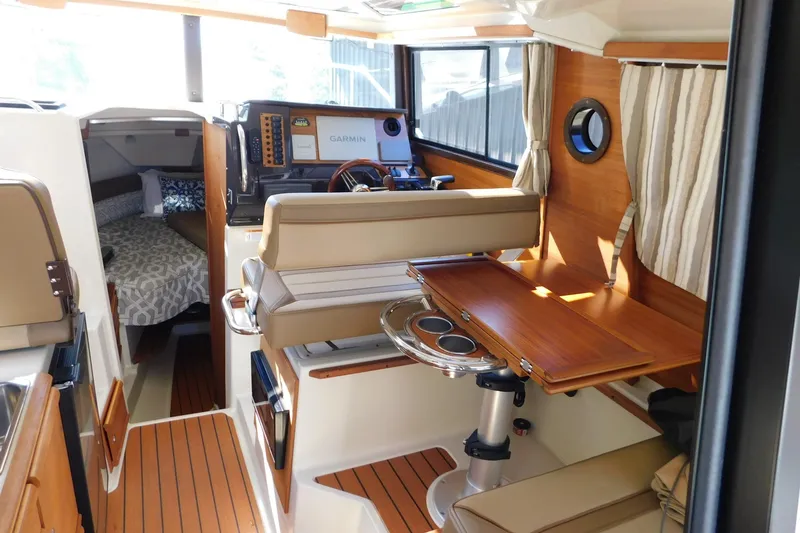 Slide: The Image of Interior of 2022 Ranger Tugs R-27 boat with helm, seating, and cabin area. - 32