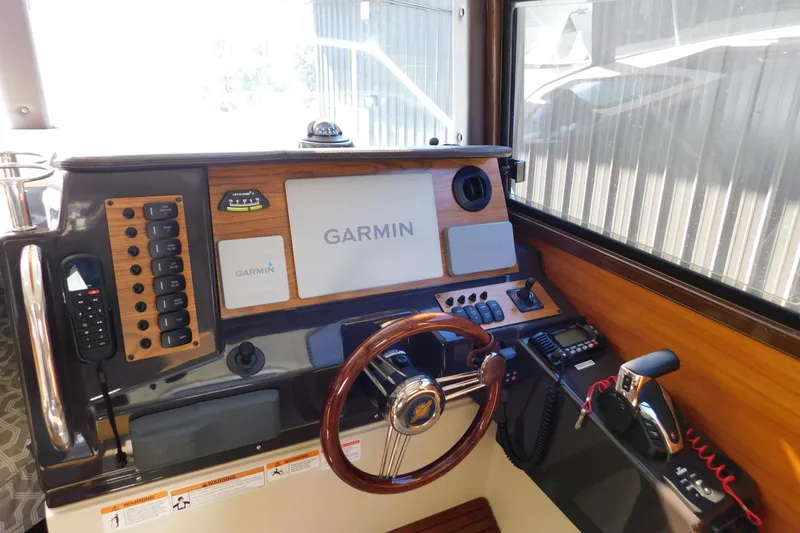 Slide: The Image of 2022 Ranger Tugs R-27 helm with Garmin navigation system and wooden steering wheel. - 35