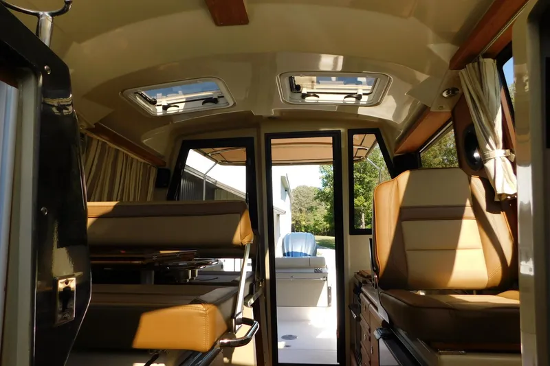 Slide: The Image of Interior view of 2022 Ranger Tugs R-27 boat, featuring seating and natural light. - 39