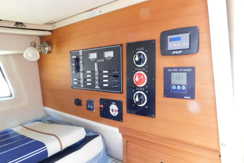 Slide: The Image of 2022 Ranger Tugs R-27 interior control panel with electrical switches and charging display. - 42