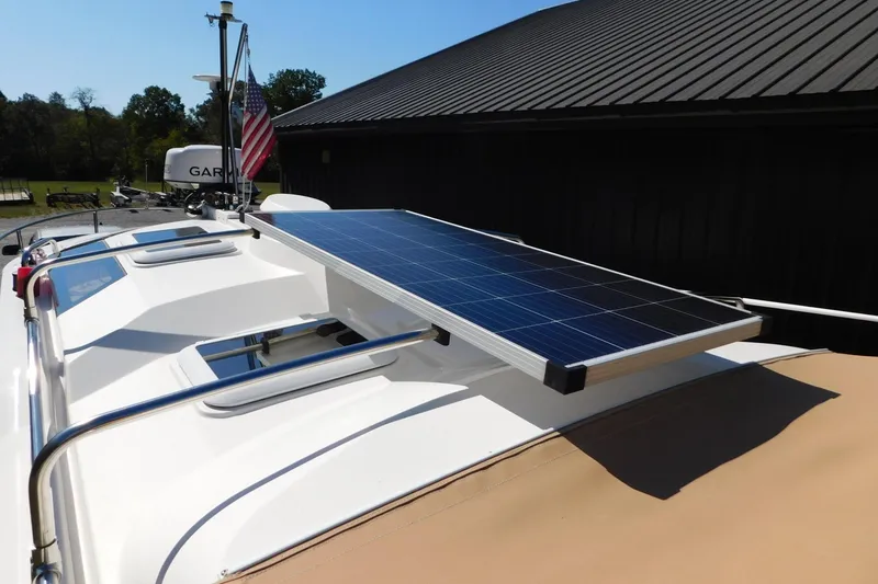 Slide: The Image of 2022 Ranger Tugs R-27 with solar panel on roof, American flag in background. - 44