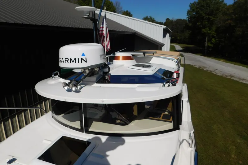 Slide: The Image of 2022 Ranger Tugs R-27 boat with Garmin radar, docked near a building. - 48