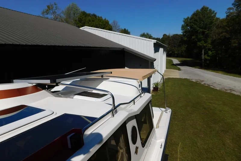 Slide: The Image of 2022 Ranger Tugs R-27 boat parked near a building, showcasing its roof and surroundings. - 49