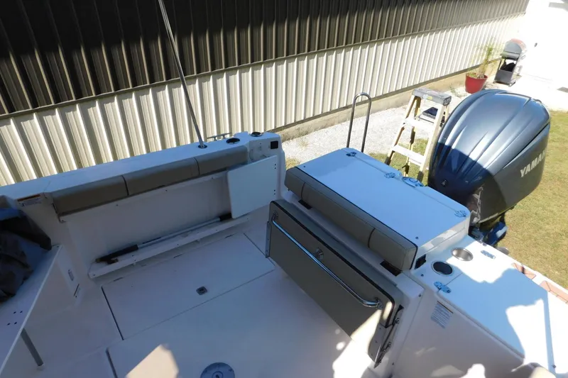 Slide: The Image of 2022 Ranger Tugs R-27 boat deck with Yamaha outboard motor, docked near a building. - 50