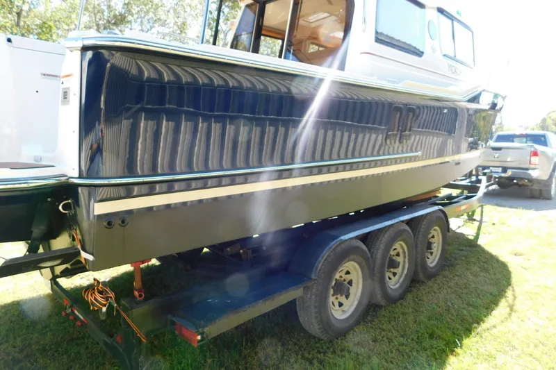 Slide: The Image of 2022 Ranger Tugs R-27 boat on a trailer, side view in sunlight. - 59
