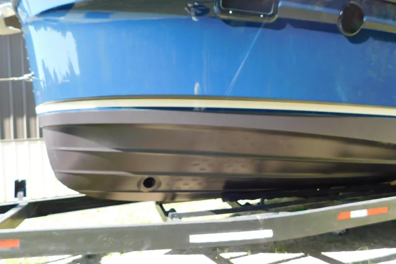 Slide: The Image of 2022 Ranger Tugs R-27 boat hull on trailer, showcasing sleek blue and black design. - 60