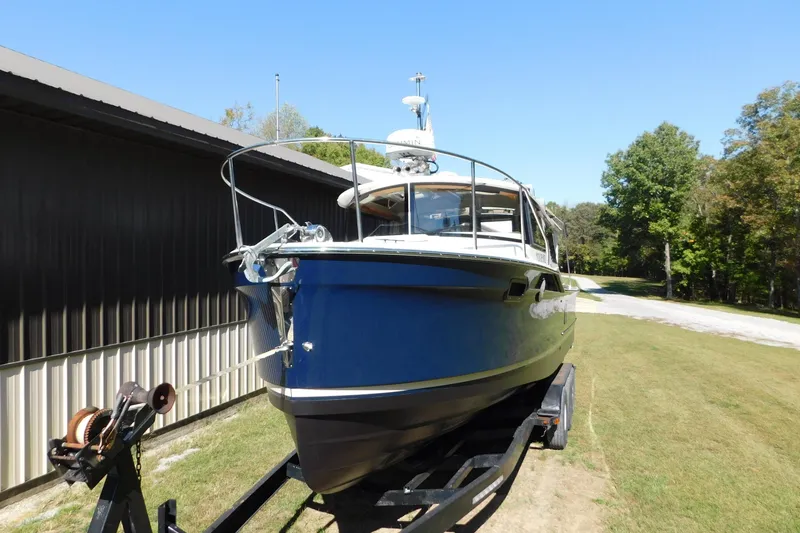 Slide: The Image of 2022 Ranger Tugs R-27 boat on trailer, parked outdoors near a building. - 62