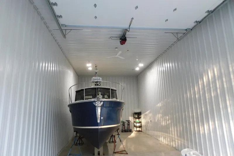 Slide: The Image of 2022 Ranger Tugs R-27 boat stored in a spacious indoor facility. - 65