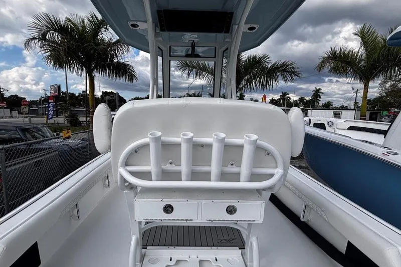 Slide: The Image of 2026 Tidewater 2500 Carolina Bay boat interior with rod holders and palm trees in the background. - 14