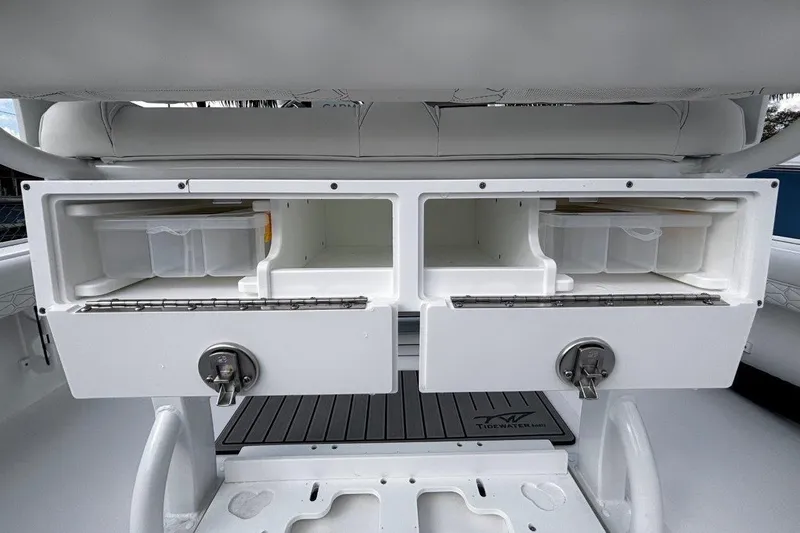 Slide: The Image of 2026 Tidewater 2500 Carolina Bay boat storage compartments with secure latches and organized interior. - 15