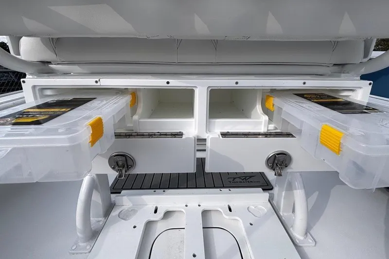 Slide: The Image of 2026 Tidewater 2500 Carolina Bay boat storage compartments with tackle boxes. - 16