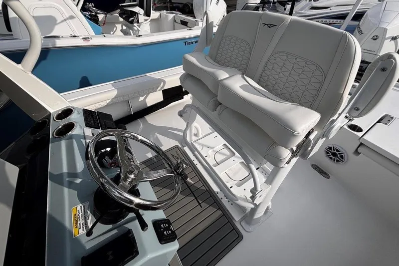 Slide: The Image of 2026 Tidewater 2500 Carolina Bay boat interior with steering wheel and cushioned seating. - 17
