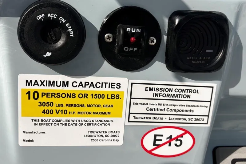 Slide: The Image of 2026 Tidewater 2500 Carolina Bay capacity and emission control labels, featuring engine and weight limits. - 24