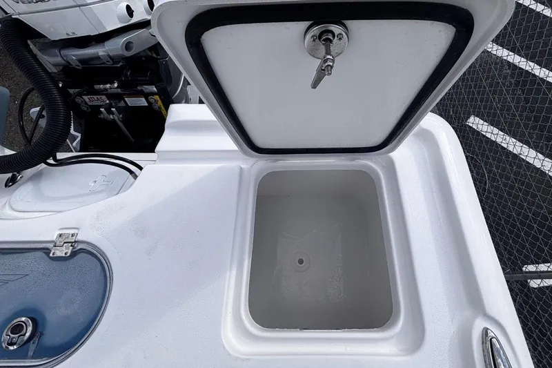 Slide: The Image of 2026 Tidewater 2500 Carolina Bay boat storage compartment with open lid and visible engine. - 32