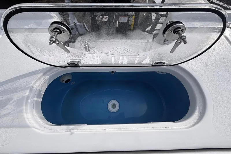 Slide: The Image of Livewell compartment on 2026 Tidewater 2500 Carolina Bay boat, featuring a clear lid and blue interior. - 33