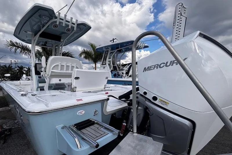 Slide: The Image of 2026 Tidewater 2500 Carolina Bay boat with Mercury engine, docked under cloudy sky. - 4