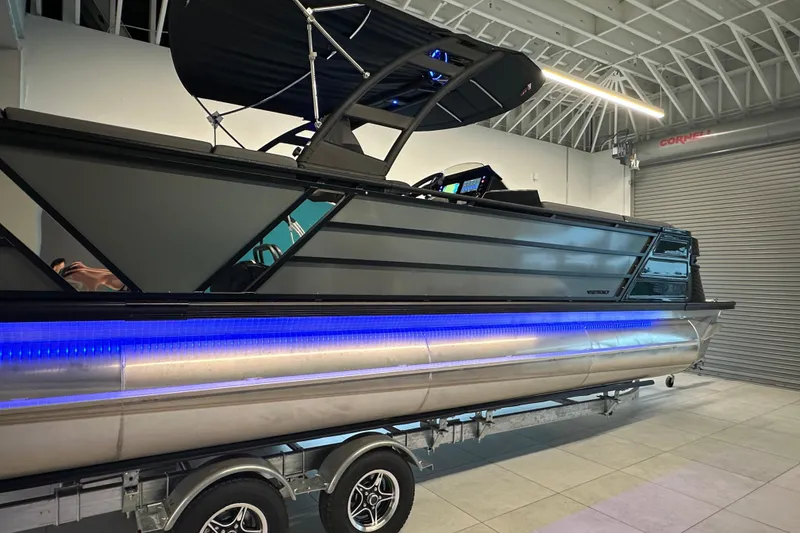 Slide: The Image of 2025 Veranda VX 27 DCRC pontoon boat with sleek design and blue LED lighting. - 18
