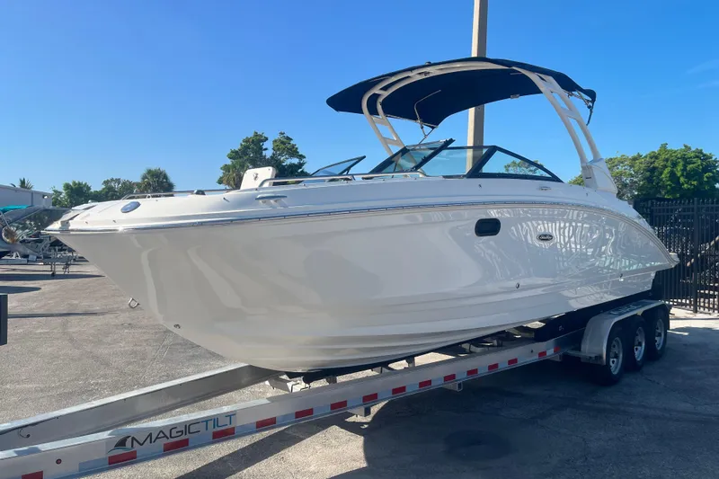 Slide: The Image of 2024 Sea Ray SDX 270 Outboard boat on trailer, sunny day, blue sky. - 1