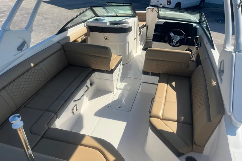 Slide: The Image of 2024 Sea Ray SDX 270 Outboard interior with tan seating and modern dashboard. - 10