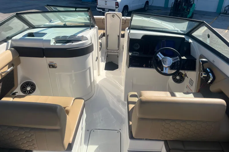 Slide: The Image of 2024 Sea Ray SDX 270 Outboard interior with beige seating and modern dashboard. - 9