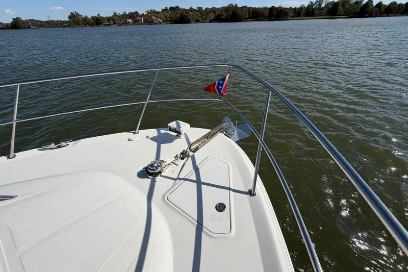 Slide: The Image of Bow view of 2003 Sea Ray 560 Sedan Bridge on a calm lake. - 7