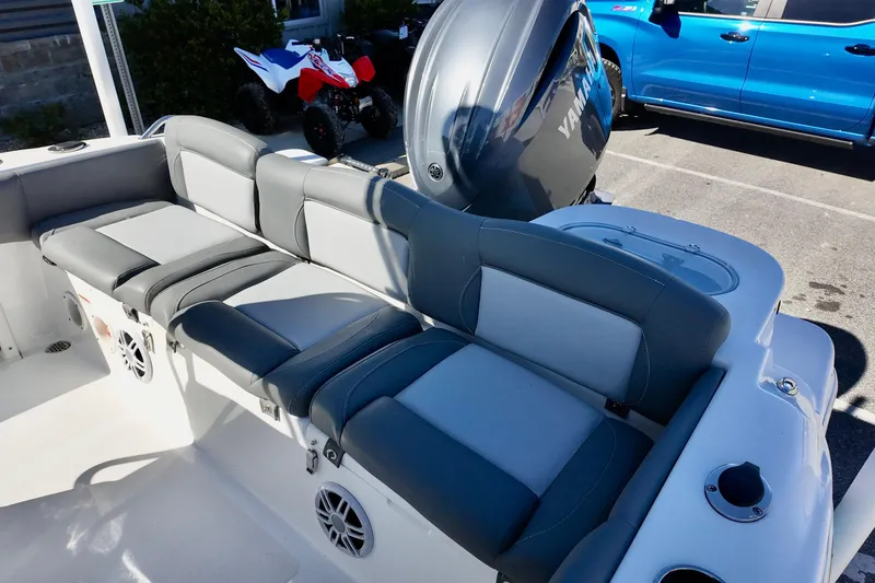 Slide: The Image of 2025 NauticStar 212 Legacy boat interior with Yamaha engine, featuring gray seating and speakers. - 12