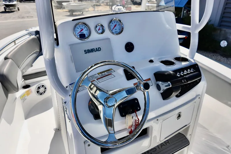 Slide: The Image of 2025 NauticStar 212 Legacy boat dashboard with steering wheel and gauges. - 13
