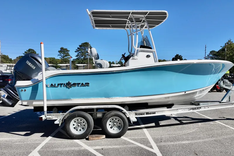 Slide: The Image of 2025 NauticStar 212 Legacy boat on trailer, featuring Yamaha engine, parked outdoors. - 6