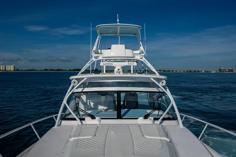 Slide: The Image of 2023 Intrepid 477 Evolution yacht cruising on open water under clear blue skies. - 18