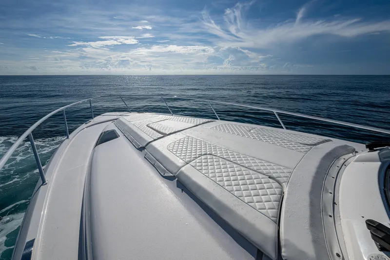 Slide: The Image of 2023 Intrepid 477 Evolution yacht cruising on open sea under clear blue sky. - 19