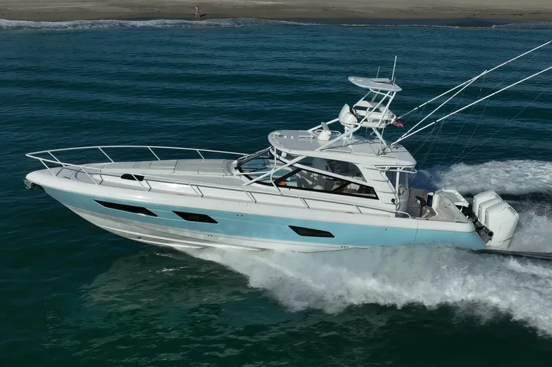 Slide: The Image of 2023 Intrepid 477 Evolution yacht cruising on ocean near sandy shore. - 3