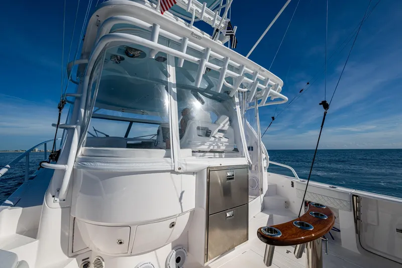 Slide: The Image of 2023 Intrepid 477 Evolution yacht on open sea, showcasing sleek design and fishing equipment. - 47