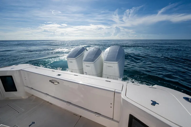 Slide: The Image of 2023 Intrepid 477 Evolution boat with triple outboard engines on open sea. - 52