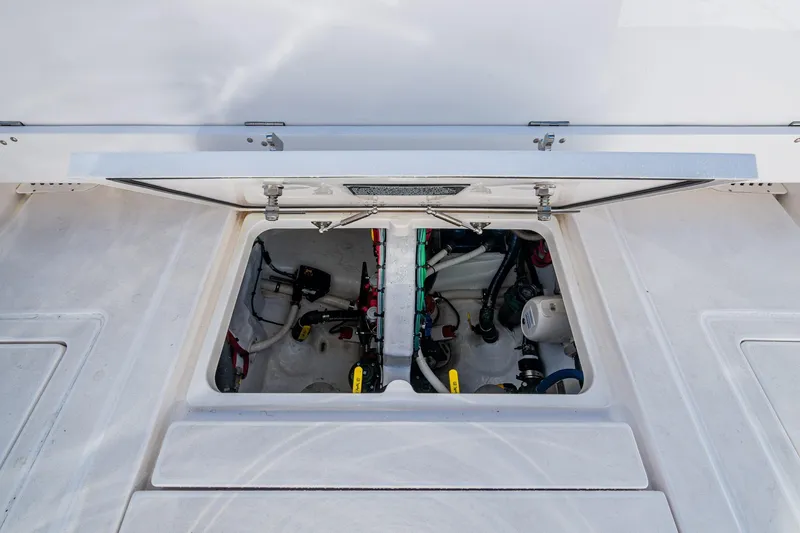 Slide: The Image of 2023 Intrepid 477 Evolution boat engine compartment with open hatch, showcasing internal components. - 54