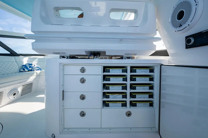 Slide: The Image of 2023 Intrepid 477 Evolution boat interior with organized storage compartments and modern design. - 58