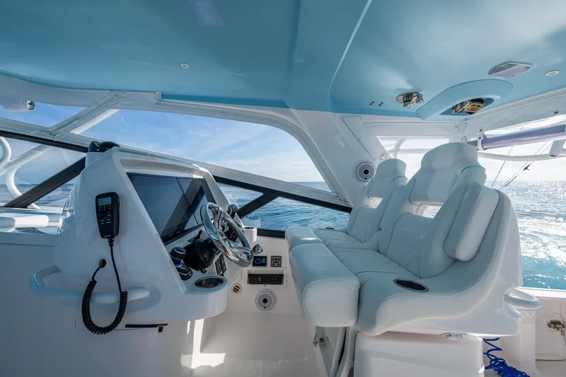 Slide: The Image of 2023 Intrepid 477 Evolution yacht cockpit with luxurious seating and advanced navigation controls. - 61