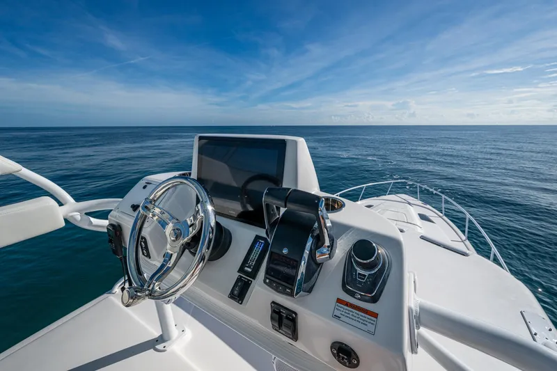 Slide: The Image of 2023 Intrepid 477 Evolution helm with ocean view, featuring modern controls and steering wheel. - 92