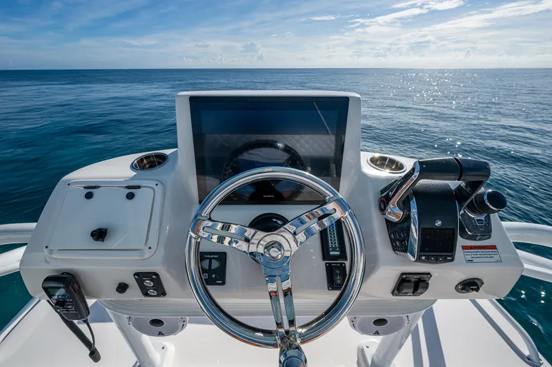 Slide: The Image of Helm of 2023 Intrepid 477 Evolution boat with ocean view, featuring modern controls and steering. - 93