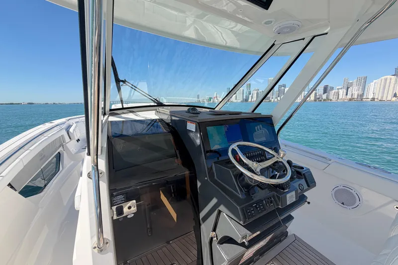Slide: The Image of 2021 Pursuit S 378 Sport boat helm with city skyline in background. - 10