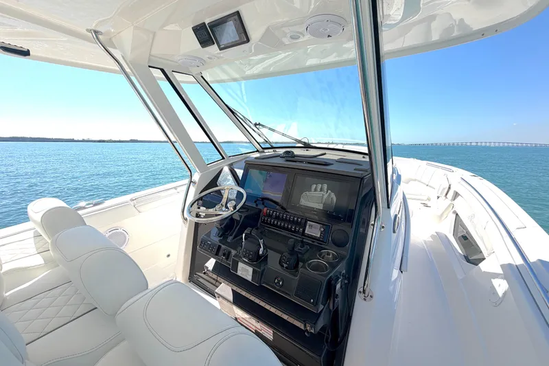 Slide: The Image of 2021 Pursuit S 378 Sport boat interior with modern helm and ocean view. - 11