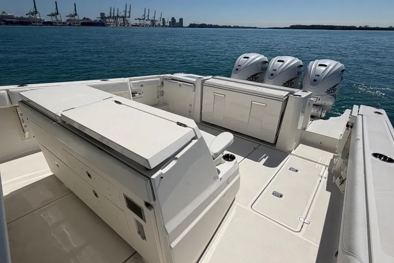 Slide: The Image of 2021 Pursuit S 378 Sport boat with triple outboard engines on calm water. - 8