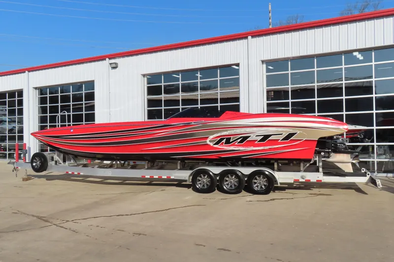 Slide: The Image of Red 2010 MTI 36 R/P speedboat on trailer outside a garage. - 1