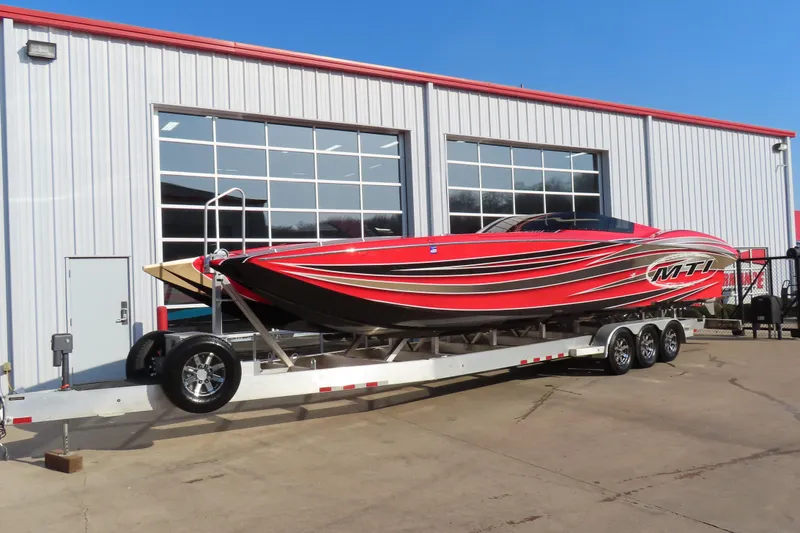Slide: The Image of Red 2010 MTI 36 R/P speedboat on trailer outside a garage. - 2