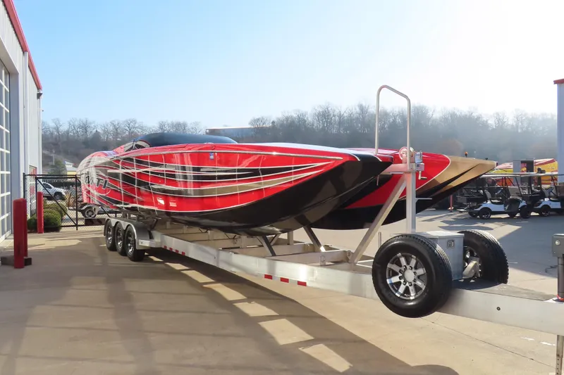 Slide: The Image of 2010 MTI 36 R/P powerboat on trailer, red and black design, parked outdoors. - 6