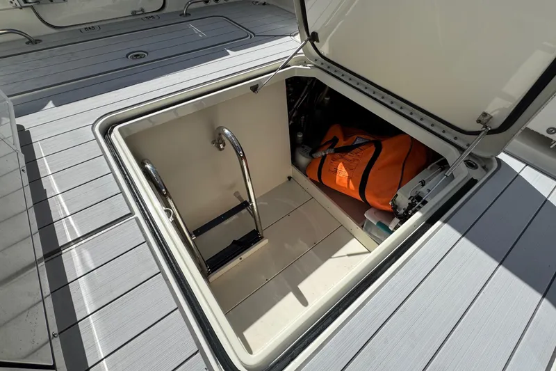 Slide: The Image of Open storage compartment on 2017 HCB 42 Siesta boat with orange bag and ladder. - 23